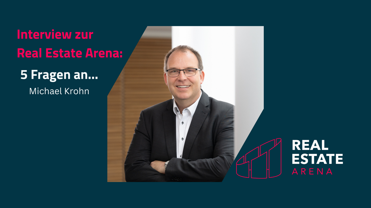 Das Bild zeigt einen professionell gekleideten Mann mit Brille, der lächelnd vor einem hellen Hintergrund steht. Neben ihm befindet sich der Text "Interview zur Real Estate Arena: 5 Fragen an... Michael Krohn" in einem modernen, ansprechenden Design.
