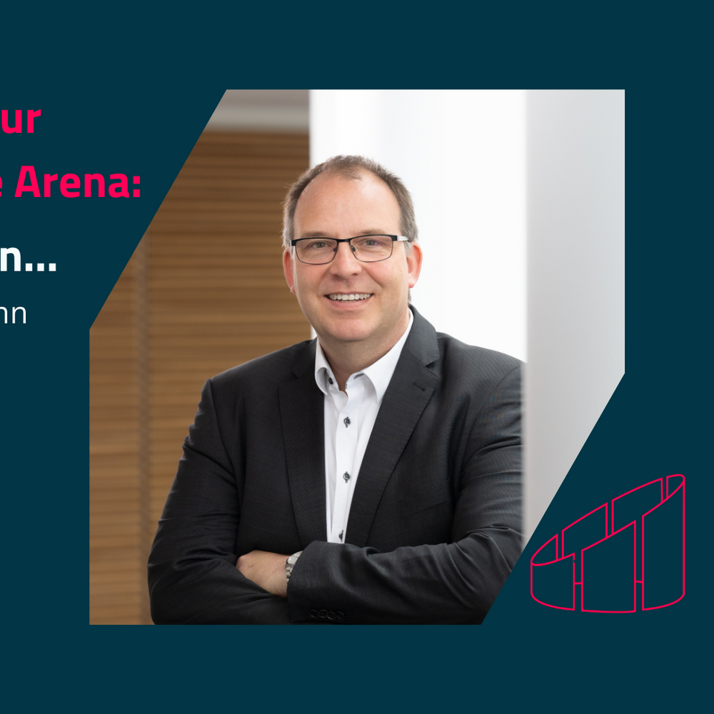 Das Bild zeigt einen professionell gekleideten Mann mit Brille, der lächelnd vor einem hellen Hintergrund steht. Neben ihm befindet sich der Text "Interview zur Real Estate Arena: 5 Fragen an... Michael Krohn" in einem modernen, ansprechenden Design.