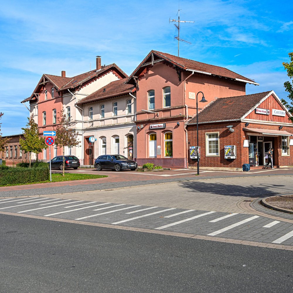 Das Bahnhofsgebäude in Walsrode in einer Frontalansicht mit Sicht auf den Bahnhofsvorplatz