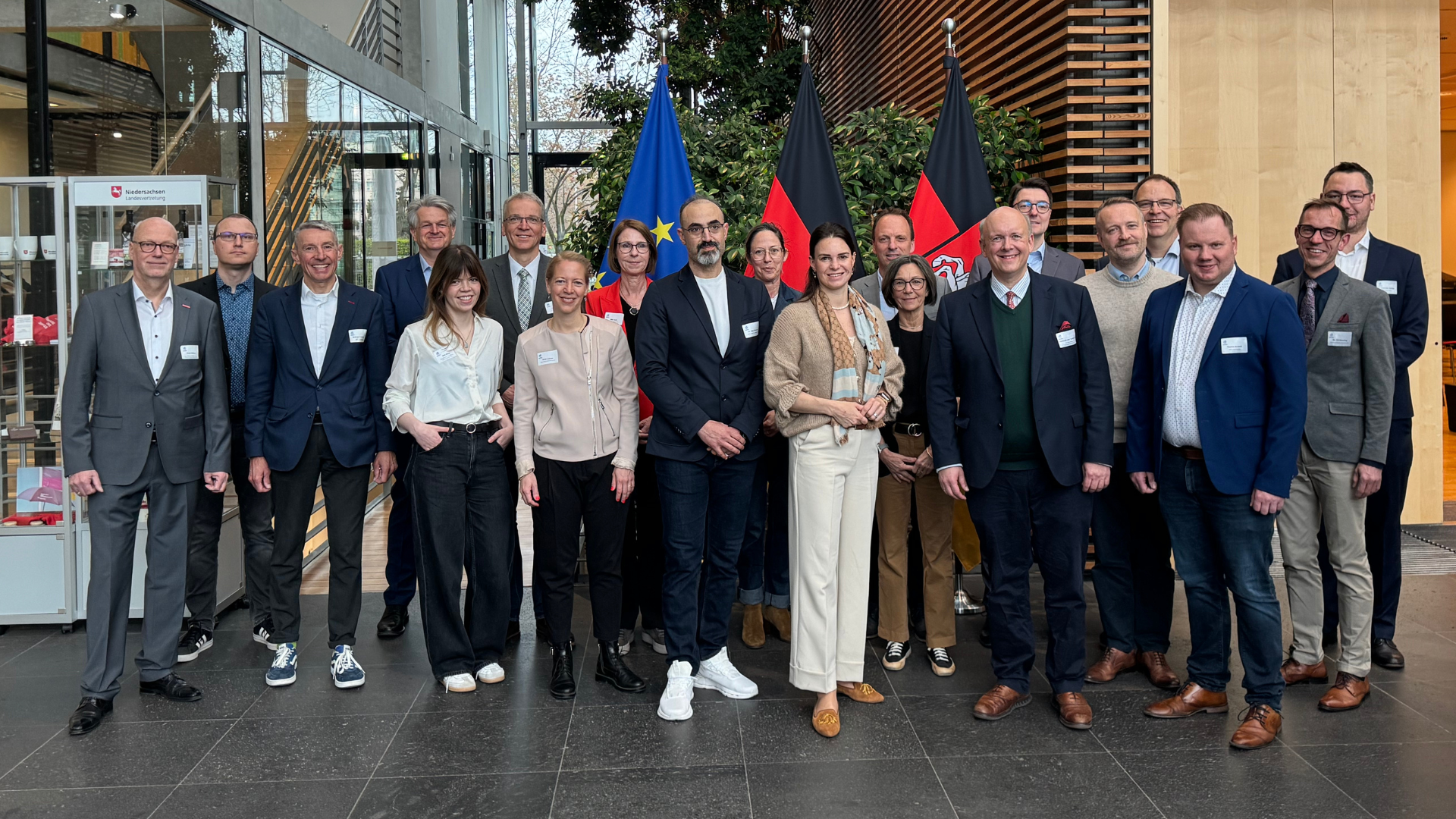 Gruppenfoto der Teilnehmenden des dritten H2.N.O.N-Hauptstadtfrühstücks am 14. April 2026 in der Vertretung des Landes Niedersachsen beim Bund in Berlin. Vor EU-Fahne und Deutschlandfahne versammeln sich rund 20 Vertreterinnen und Vertreter aus Wirtschaft, Netzwerk und Politik zum gemeinsamen Austausch über den Markthochlauf der Wasserstoffwirtschaft.