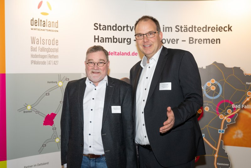 Das Bild zeigt zwei Männer, die lächelnd vor einem Banner stehen, das Informationen über die Region Walsrode enthält. Die Atmosphäre wirkt professionell und freundlich, was auf eine Networking-Veranstaltung hindeutet.
