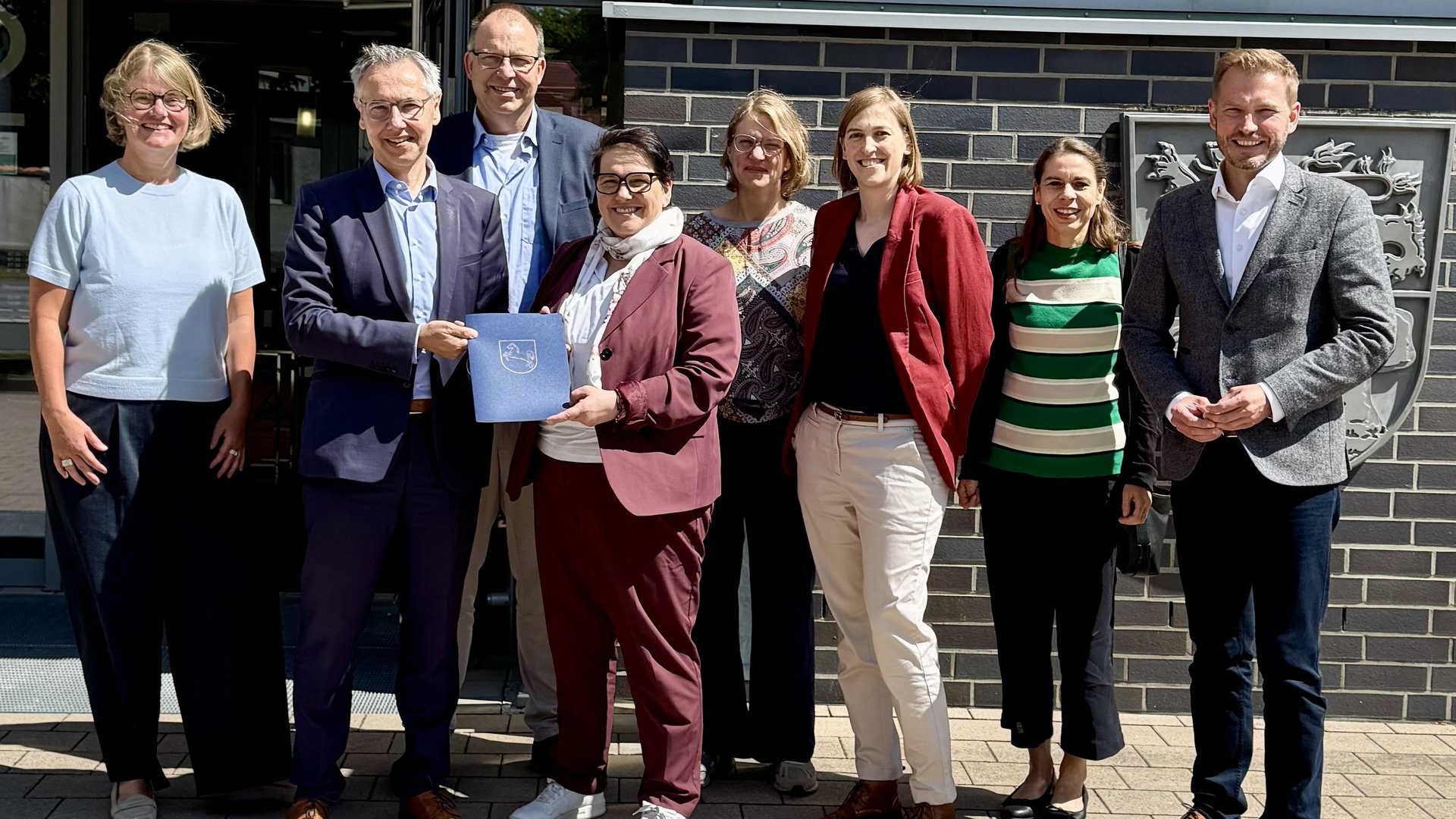 Das Foto ist ein Gruppenbild von 8 Personen bei der Übergabe eines Fördermittelbescheids. Zu sehen sind: Anke von Fintel (Landkreis Heidekreis), Landrat Jens Grote, Deltaland-Geschäftsführer Michael Krohn, Ministerin Melanie Walter, Dr. Theresa Weinsziehr (Energieagentur Heidekreis), Cornelia von Zengen (Landkreis Heidekreis),  Stefani Thomas (Amt für regionale Landesentwicklung), Sebastian Zinke (Mitglied des Landtags)