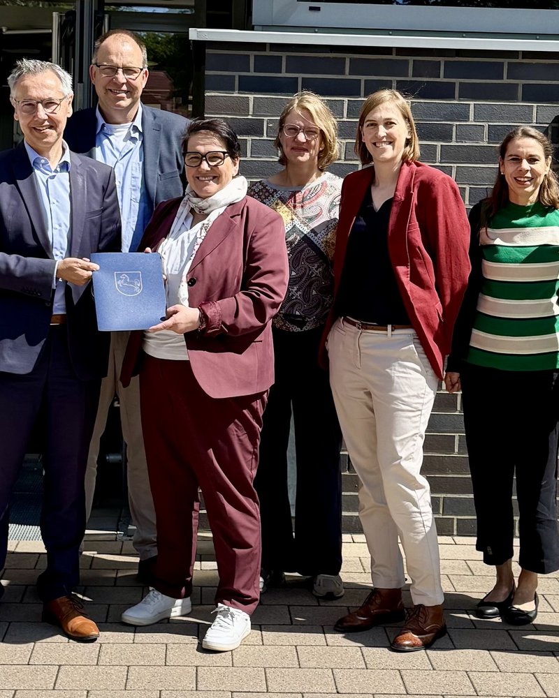 Das Foto ist ein Gruppenbild von 8 Personen bei der Übergabe eines Fördermittelbescheids. Zu sehen sind: Anke von Fintel (Landkreis Heidekreis), Landrat Jens Grote, Deltaland-Geschäftsführer Michael Krohn, Ministerin Melanie Walter, Dr. Theresa Weinsziehr (Energieagentur Heidekreis), Cornelia von Zengen (Landkreis Heidekreis),  Stefani Thomas (Amt für regionale Landesentwicklung), Sebastian Zinke (Mitglied des Landtags)