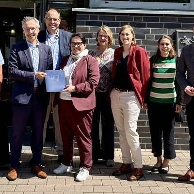 Das Foto ist ein Gruppenbild von 8 Personen bei der Übergabe eines Fördermittelbescheids. Zu sehen sind: Anke von Fintel (Landkreis Heidekreis), Landrat Jens Grote, Deltaland-Geschäftsführer Michael Krohn, Ministerin Melanie Walter, Dr. Theresa Weinsziehr (Energieagentur Heidekreis), Cornelia von Zengen (Landkreis Heidekreis),  Stefani Thomas (Amt für regionale Landesentwicklung), Sebastian Zinke (Mitglied des Landtags)
