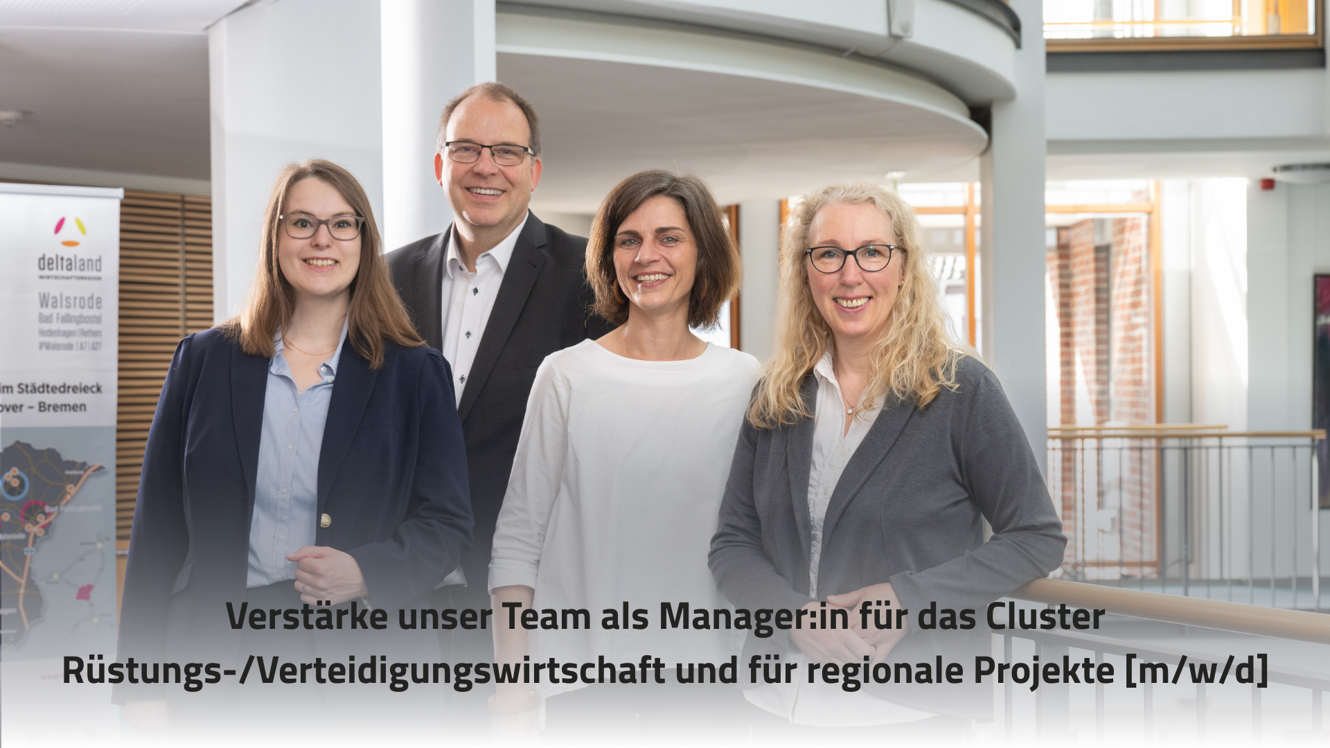 Das Bild zeigt vier Personen in einem modernen Büroumfeld, die freundlich in die Kamera lächeln. Im Vordergrund steht der Text "Verstärke unser Team als Manager:in für das Cluster Rüstungs-/Verteidigungswirtschaft und für regionale Projekte [m/w/d]".