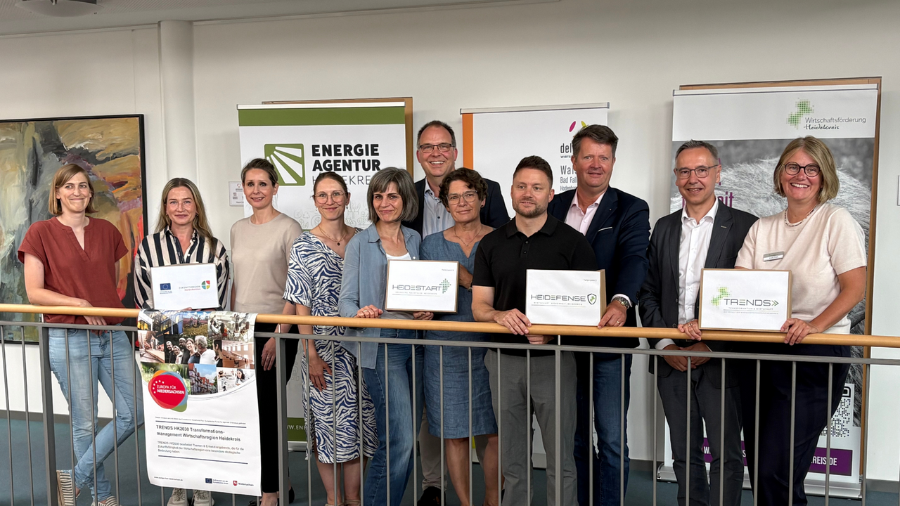 | Ⓒ Walsroder Zeitung Gruppenfoto von elf Personen beim Projektauftakt TRENDS HK2030, drei davon halten Projektschilder: HeideStart, HeiDefense und TRENDS.